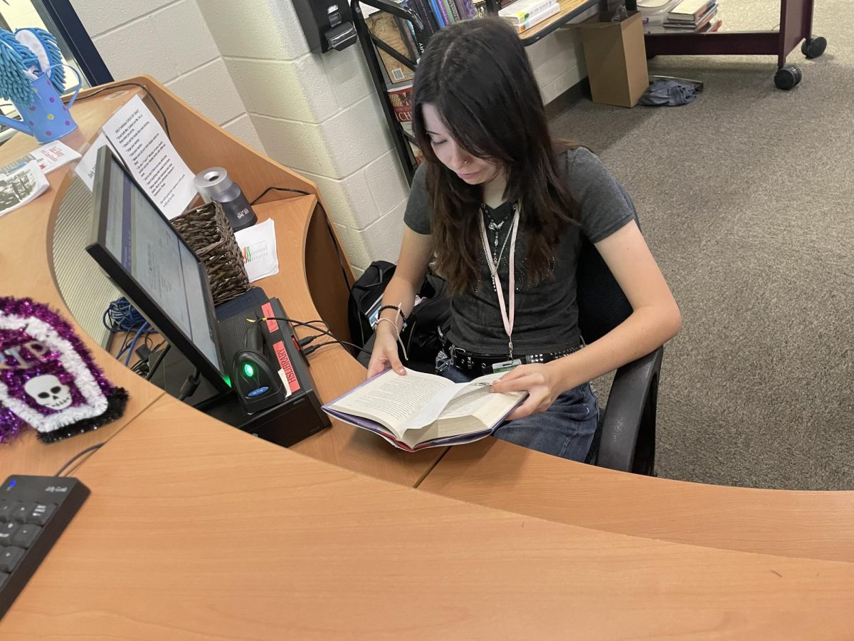 Library aid reading a book on her down time.